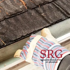 gloved hand installing gutter guard